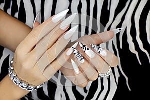 Gel manicure with animalistic pattern and accessories.