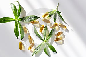 Gelatin softgels Capsules of Omega-3 fats decorated with green leaves on white background. Eicosapentaenoic acid and fish oil.