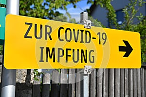 Yellow sign `To Corona vaccination` in Austria