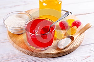 Gelling agents: gelatin, agar-agar or pectin powder with marmalade on wooden cutting board