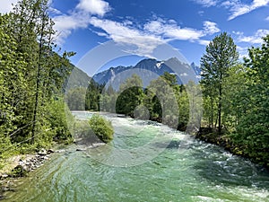 Gem green color Skykomish river with snowcapped cascade mountains in Washington State