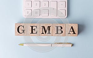 GEMBA on wooden cubes with pen and calculator, financial concept photo