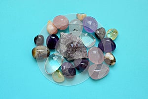 Gems of various colors. Amethyst, rose quartz, agate, apatite, aventurine, olivine, turquoise, aquamarine, rock crystal on blue