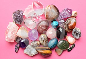 Gems of various colors. Amethyst, rose quartz, agate, apatite, aventurine, olivine, turquoise, aquamarine, rock crystal on pink