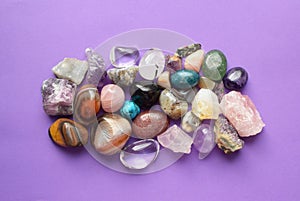 Gems of various colors. Amethyst, rose quartz, agate, apatite, aventurine, olivine, turquoise, aquamarine, rock crystal on purple