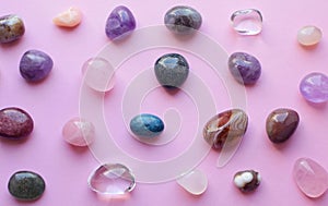 Gems of various colors. Amethyst, rose quartz, agate, apatite, aventurine, olivine, turquoise, rock crystal on pink background