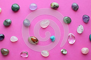 Gems of various colors. Amethyst, rose quartz, agate, apatite, aventurine, olivine, turquoise, rock crystal on pink background