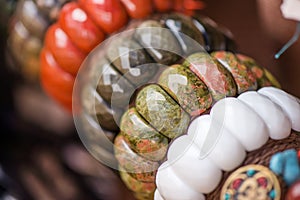 Gemstone bracelets and necklaces in a row. Jewelry made of red jasper, unakite stones, obsidian stones and white onyx stone. photo