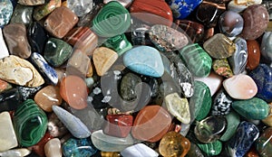 Gemstones background image. Various polished semi precious gemstones top view. Chakra healing stones and crystals. Turquoise, amet