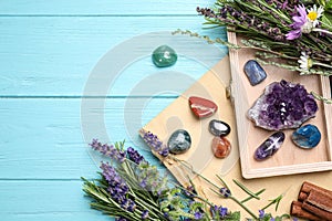 Gemstones and healing herbs on blue wooden table, flat lay. Space for text