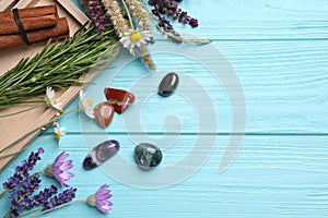 Gemstones and healing herbs on blue wooden table, flat lay. Space for text