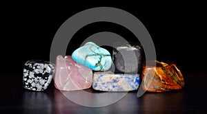 Gemstones stacked in front of black background.