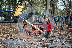 Gen z, generation z, Zoomers device addiction, digital detox. Teenager girl alone rides on a swing in an autumn park