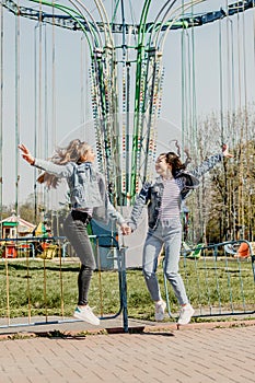 Gen z girls enjoying outdoors, expressing positive emotions. Outdoor photo of two girl friends having fun in the park