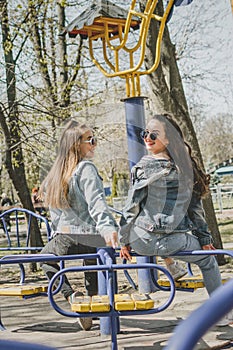 Gen z girls enjoying outdoors, expressing positive emotions. Outdoor photo of two girl friends having fun in the park