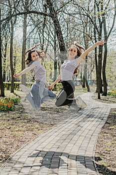 Gen z girls enjoying outdoors, expressing positive emotions. Outdoor photo of two girl friends having fun in the park