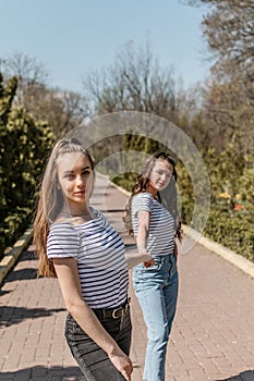 Gen z girls enjoying outdoors, expressing positive emotions. Outdoor photo of two girl friends having fun in the park