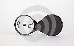 Gender equality concept.  Magnifying glass with male equals female symbol on beautiful white background. Concept, copy space