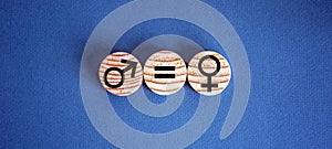 Gender equality conceptual image. Male and female symbol on wooden circles on beautiful blue background. Copy space