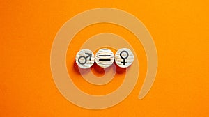 Gender equality conceptual image. Male and female symbol on wooden circles on beautiful orange background. Copy space