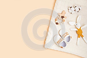 Gender neutral baby shoes and accessories over beige background.