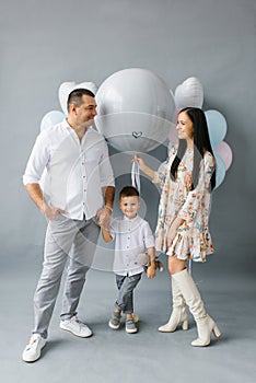 Gender reveal party. A young family waiting for their second child holds a ball to determine the sex of the unborn child