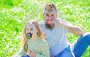 Gender roles concept. Family spend leisure outdoors. Dad and daughter sits on grassplot, grass on background. Father