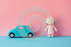 Gender stereotypical toys for children with car and doll on two-colored pink and blue background photo