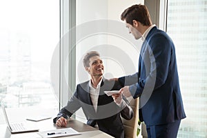 Boss giving money premium to happy employee photo