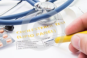 General practitioner checks cholesterol levels in patient test results on blood lipids. Statin pills, stethoscope, cholesterol tes