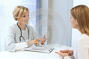 General practitioner consulting female patient in clinic