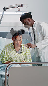 General practitioner consulting ill patient with stethoscope