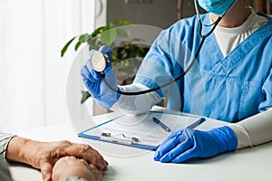 General Practitioner in doctor`s office, physician performing a blood pressure checkup photo