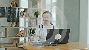 general practitioner drinks coffee while working