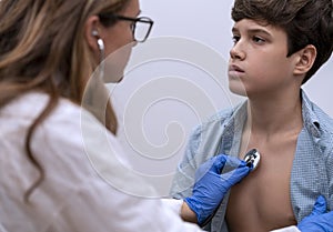 The general practitioner examines the patient with a stethoscope