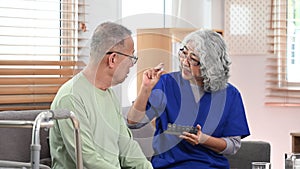 General practitioner explaining medicine dosage to senior patient during home visit