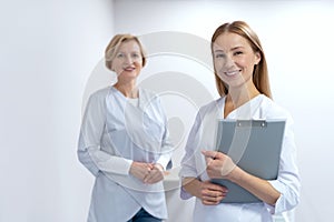 General practitioner and family doctor standing together in clinic