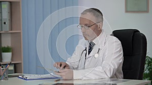 General practitioner keeping electronic medical records, contemporary medicine