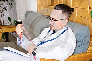 General practitioner or nutritionist holds measuring tape in his hands as he prepares to take measurement of the abdominal circumf