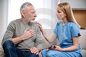 General practitioner and senior patient talking about heartache