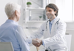 General practitioner shaking hands with healthy patient