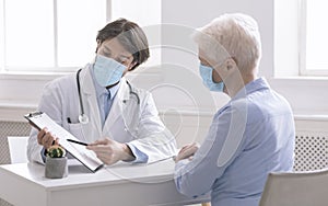 General practitioner showing analysis results to senior woman