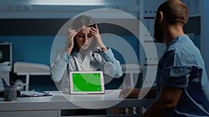 General practitioner showing medical expertise to nurse using tablet computer