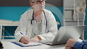 General practitioner taking checkup visit notes on documents