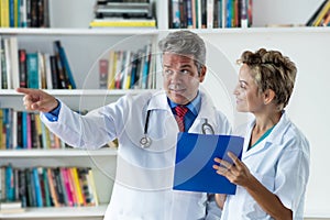 General practitioner talking about patient with female doctor photo