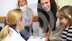 General practitioner talking to a girl in a waiting room