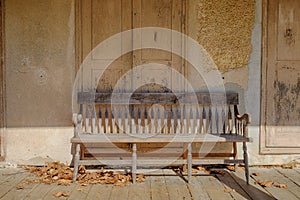 General store wall with a old weathered wooden bench