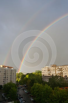 General view of a large bright double rainbow over the city.
