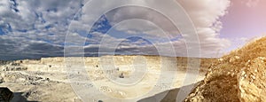 General view of open pit mine with clouded blue sky