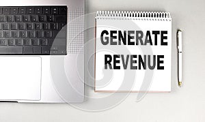 GENERATE REVENUE text on notebook with laptop and pen